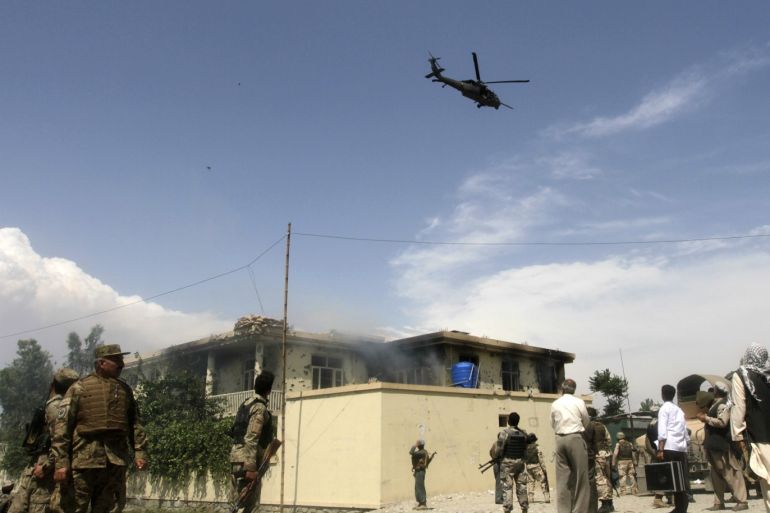 A NATO helicopter flies overhead as smoke rises from the site of a suicide attack in Jalalabad province May 12, 2014. Taliban militants launched a wave of attacks across Afghanistan on Monday, the first day of their declared summer offensive, targeting the international airport and the United States' biggest military base near Kabul. REUTERS/Parwiz (AFGHANISTAN - Tags: CIVIL UNREST POLITICS)