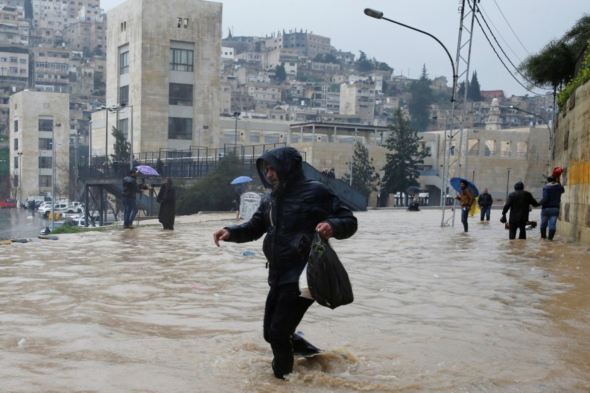 A man crosses a flooded street during heavy rains in Amman, Jordan, February 28, 2019. REUTERS/Muhammad Hamed