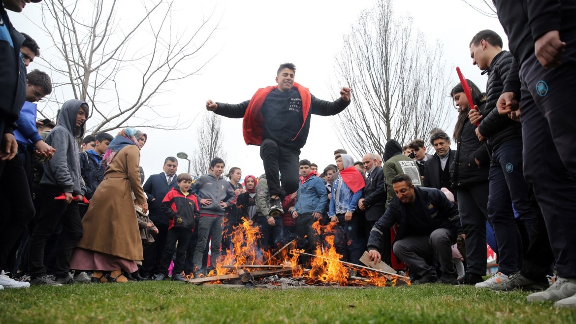 Nowruz celebrations in Istanbul- - ISTANBUL, TURKEY - MARCH 21: A boy jumps over a bonfire during the Newroz celebrations wearing traditional clothes, participate in Nowruz celebrations at Topkapı Culture Park in Istanbul, Turkey on March 21, 2019.
