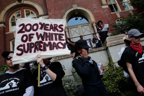 CHARLOTTESVILLE, VA - AUGUST 11: Protesters with the group Students Act Against White Supremacy speak on the campus of the University of Virginia during an event marking the one year anniversary of a deadly clash between white supremacists and counter protesters August 11, 2018 in Charlottesville, Virginia. Charlottesville has been declared in a state of emergency by Virginia Gov. Ralph Northam as the city braces for the one year anniversary of the deadly clash between white supremacist forces and counter protesters over the potential removal of Confederate statues of Robert E. Lee and Stonewall Jackson. A ÒUnite the RightÓ rally featuring some of the same groups is planned for tomorrow in Washington, DC. Win McNamee/Getty Images/AFP== FOR NEWSPAPERS, INTERNET, TELCOS & TELEVISION USE ONLY ==