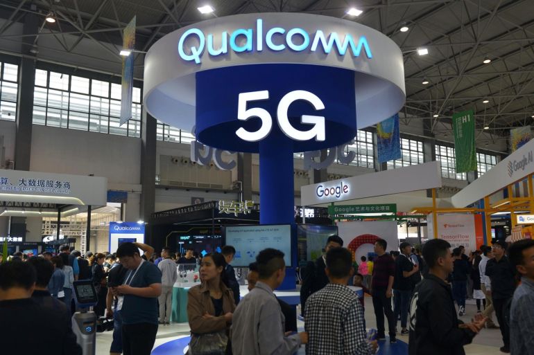 Visitors are seen by a booth of Qualcomm Inc at the China International Big Data Industry Expo in Guiyang, Guizhou province, China May 27, 2018. Picture taken May 27, 2018.  REUTERS/Stringer ATTENTION EDITORS - THIS IMAGE WAS PROVIDED BY A THIRD PARTY. CHINA OUT.