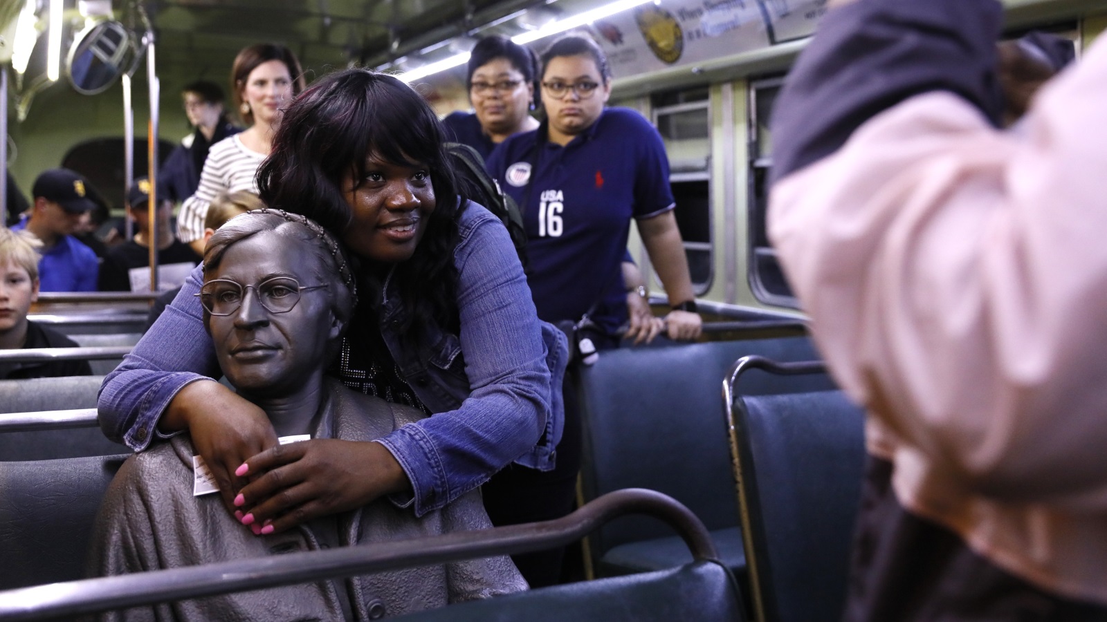 ‪معلمة تعانق تمثال روزا على متن حافلة في المتحف الوطني للحقوق المدنية‬  (رويترز)