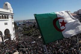 An Algerian flag flutters as people gather during a protest over President Abdelaziz Bouteflika's decision to postpone elections and extend his fourth term in office, in Algiers, Algeria March 15, 2019. REUTERS/Zohra Bensemra