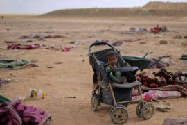 A child sits in a baby carriage near the village of Baghouz, Deir Al Zor province, in Syria March 7, 2019. Picture taken March 7, 2019. REUTERS/Rodi Said