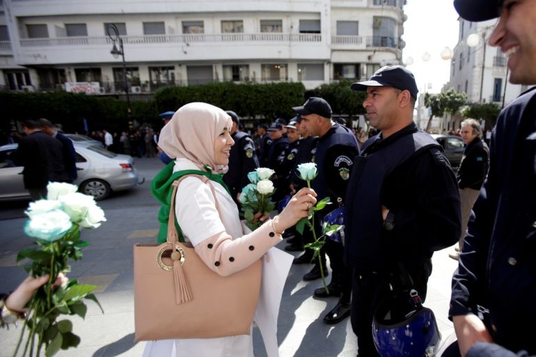 A demonstrator offers a flower to a police officer as teachers and students take part in a protest demanding immediate political change in Algiers, Algeria March 13, 2019. REUTERS/Ramzi Boudina