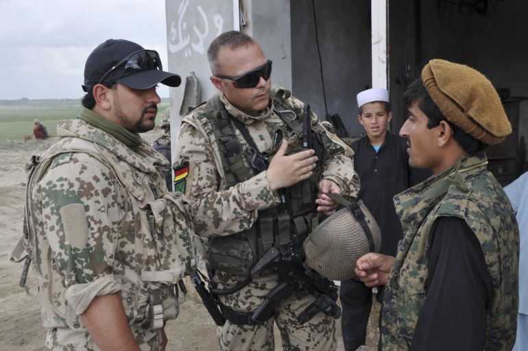 A German soldier (C), accompanied by an Afghan translator in a German uniform, talks to an inhabitant of the village Arab Sher Ali in northern Chahar Darrah in this April 24, 2012 file photo. The soldiers wanted to find out about the mood among the Afghans, and were also looking for information after two Belgian soldiers were wounded by an IED the day before in neighbouring Qara Yatim village. The German military lost more soldiers in this region due to fights and attac