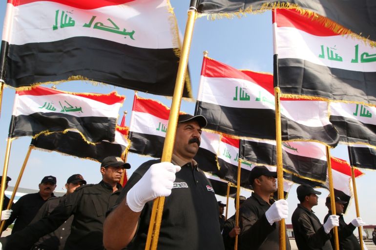 Riot police officers hold Iraqi flags during a graduation ceremony, after completing their training at the police academy, in Basra, Iraq November 12, 2018, REUTERS/Essam al-Sudani