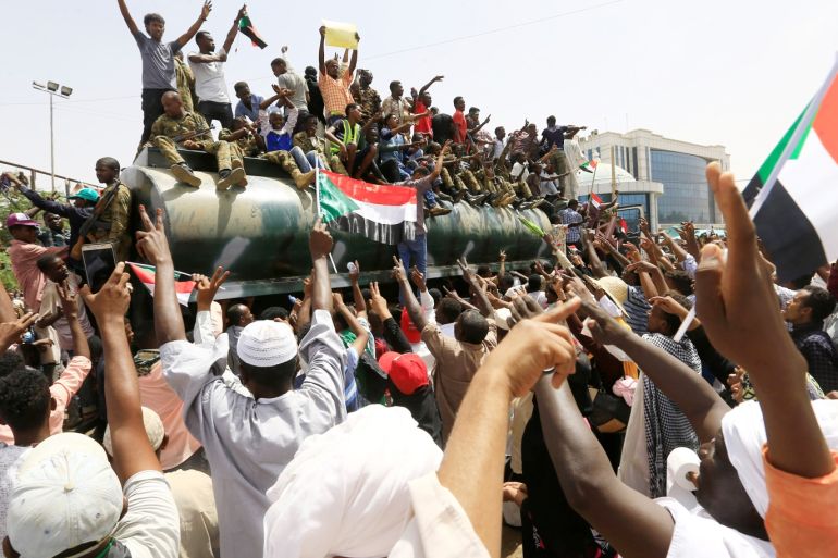 Sudanese demonstrators ride atop a military tanker and wave their national flags as they protest against the army's announcement that President Omar al-Bashir would be replaced by a military-led transitional council, near Defence Ministry in Khartoum, Sudan April 12, 2019. REUTERS/Stringer