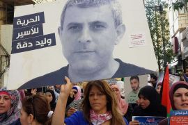 ميرفت صادق فلسطين رام الله 9 أبريل 2019 زوجة الأسير وليد دقة تحمل صورته في مسيرة لدعم إضراب الأسرى الثلاثاء وسط رام الله قبل يوم من نقله إلى العزل.psd