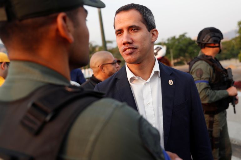 Venezuelan opposition leader Juan Guaido, who many nations have recognised as the country's rightful interim ruler, talks with a military member near the Generalisimo Francisco de Miranda Airbase
