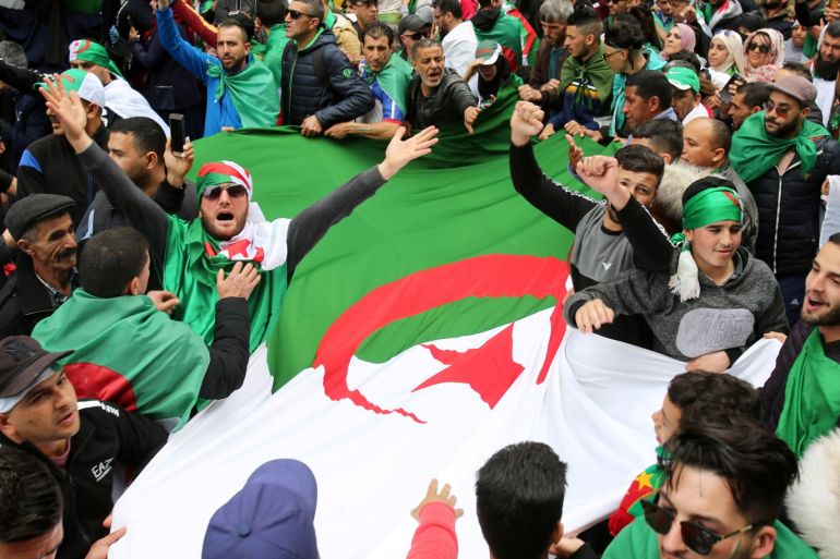 People carry a national flag during a protest to push for the removal of the current political structure, in Algiers, Algeria April 5, 2019. REUTERS/Ramzi Boudina