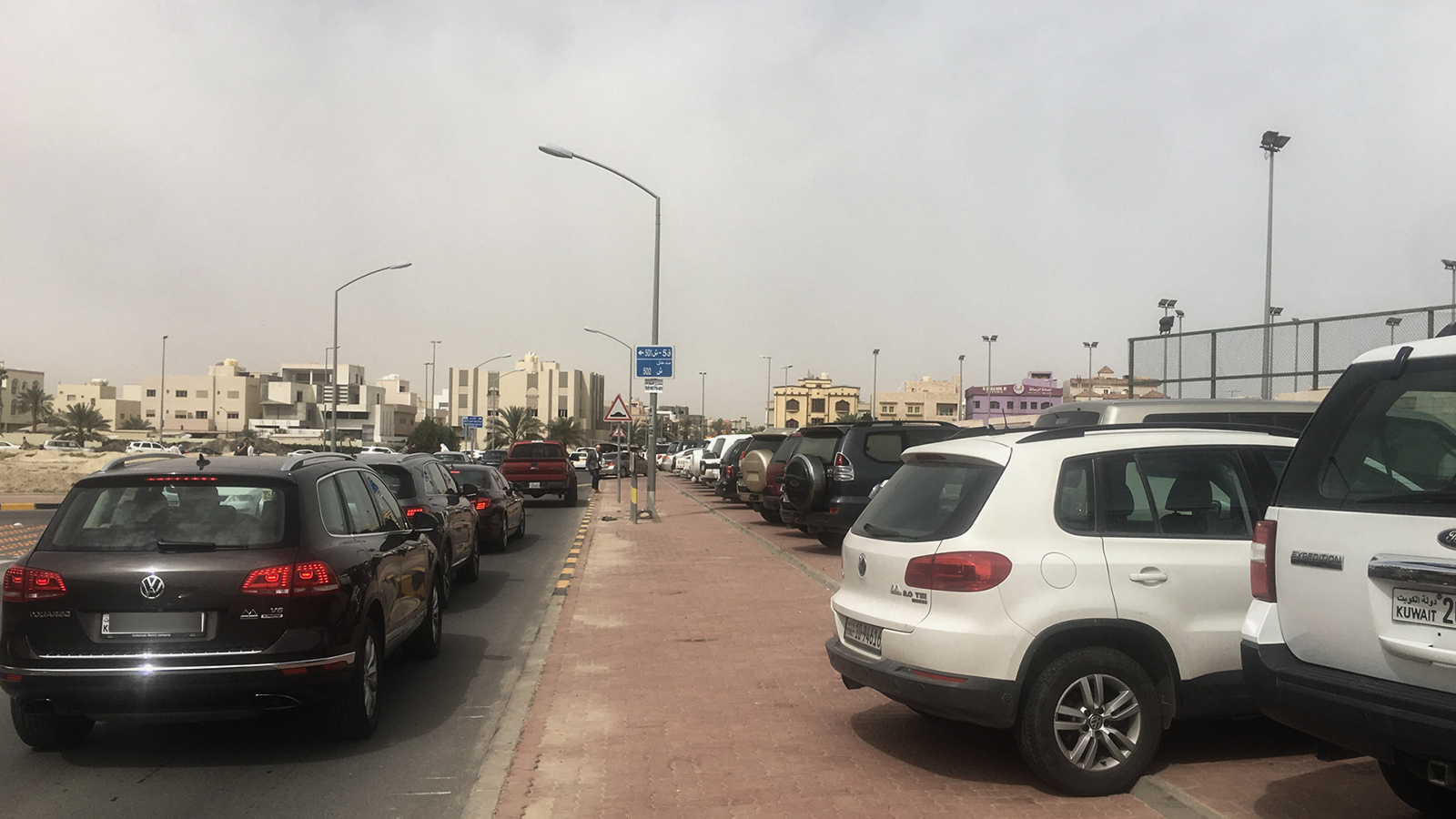 سيارات في مواقف مخالفة بحرم إحدى المدارس المجاورة للقنصلية(الجزيرة نت)