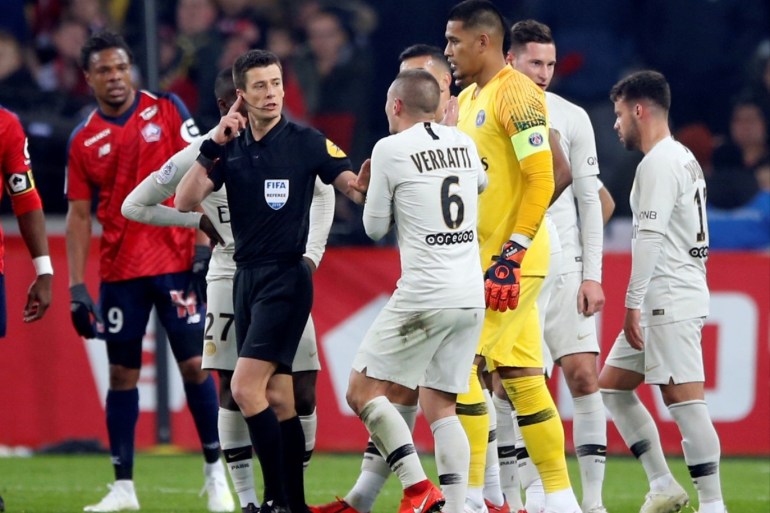 Soccer Football - Ligue 1 - Lille v Paris St Germain - Stade Pierre-Mauroy, Lille, France - April 12, 2019 Paris St Germain's Marco Verratti, Alphonse Areola and team mates remonstrate with referee Benoit Bastien before Juan Bernat was shown a red card REUTERS/Pascal Rossignol