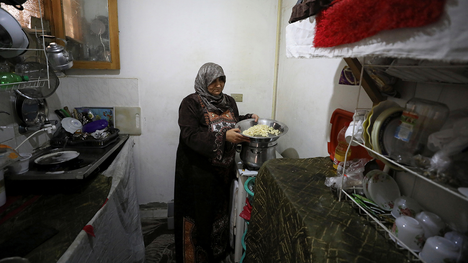 اللاجئة السورية إلهام محمد تقوم بإعداد الغداء في منزلها بالقاهرة (رويترز)