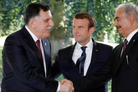 French President Emmanuel Macron stands between Libyan Prime Minister Fayez al-Sarraj (L), and General Khalifa Haftar (R), commander in the Libyan National Army (LNA), who shake hands after talks over a political deal to help end Libya’s crisis in La Celle-Saint-Cloud near Paris, France, July 25, 2017. REUTERS/Philippe Wojazer TPX IMAGES OF THE DAY