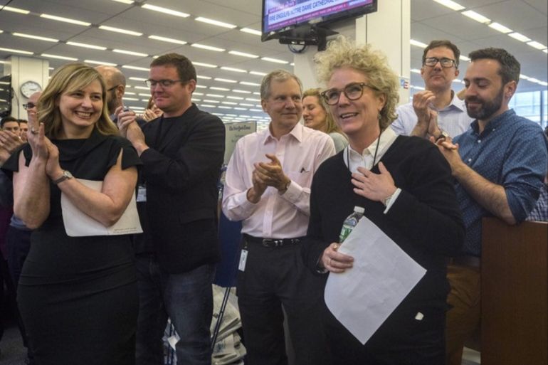 epa07509157 A handout photo made available by The New York Times showing New York Times journalist Susanne Craig, foreground center, is applauded by New York Times Co. Chairman Arthur Sulzberger Jr., third from left, and other colleagues in the newsroom in New York, New York, USA, 15 April 2019. Craig, along with colleagues David Barstow and Russ Buettner, won the Pulitzer Prize for Explanatory Reporting for a forensic review of President Donald Trump’s family finances,