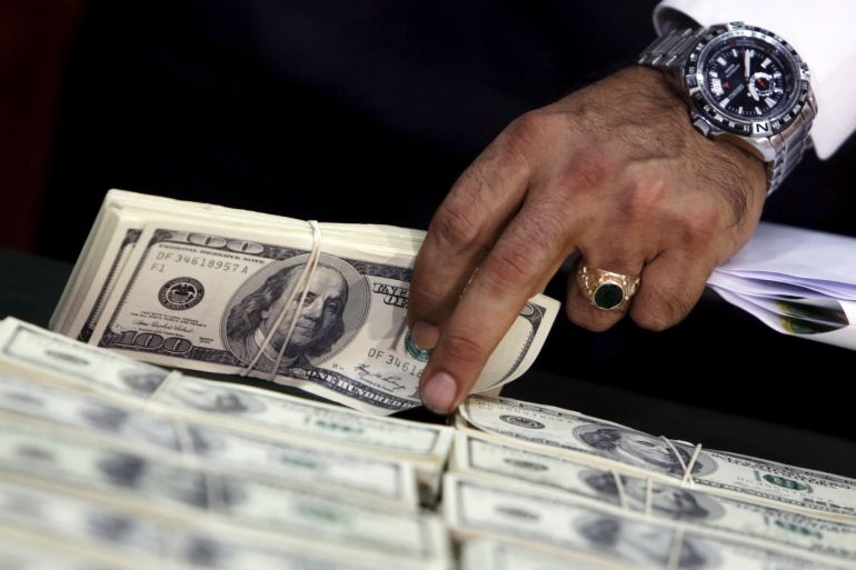 Police officers display counterfeit U.S. dollar bills during a news conference in Lima October 14, 2015. The National Police seized $836,000 in fake bills that had been packed in bags and backpacks destined for the city of New York in the United States, according to a police media release. REUTERS/Guadalupe Pardo