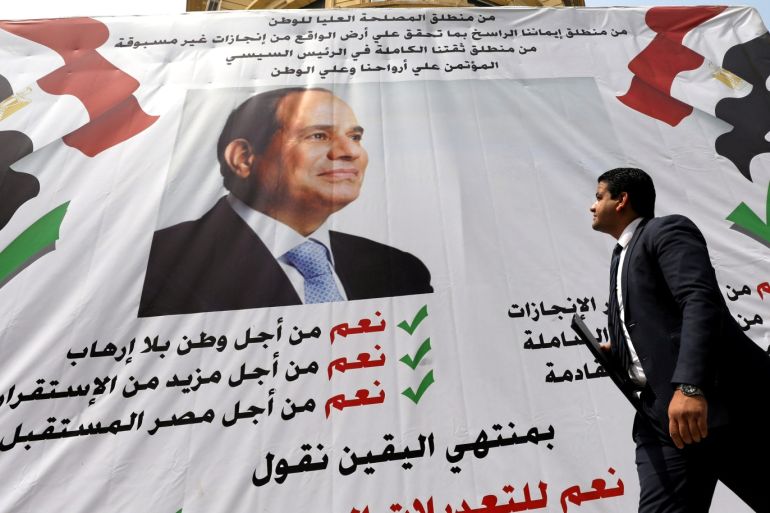 A man walks in front of a banner reading, "Yes to the constitutional amendments, for a better future", with a photo of the Egyptian President Abdel Fattah al-Sisi before the approaching referendum on constitutional amendments in Cairo, Egypt April 16, 2019. REUTERS/Mohamed Abd El Ghany