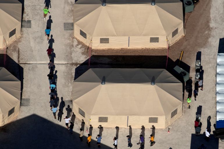 Immigrant children are led by staff in single file between tents at a detention facility next to the Mexican border in Tornillo, Texas, U.S., June 18, 2018. Reuters photographer Mike Blake: