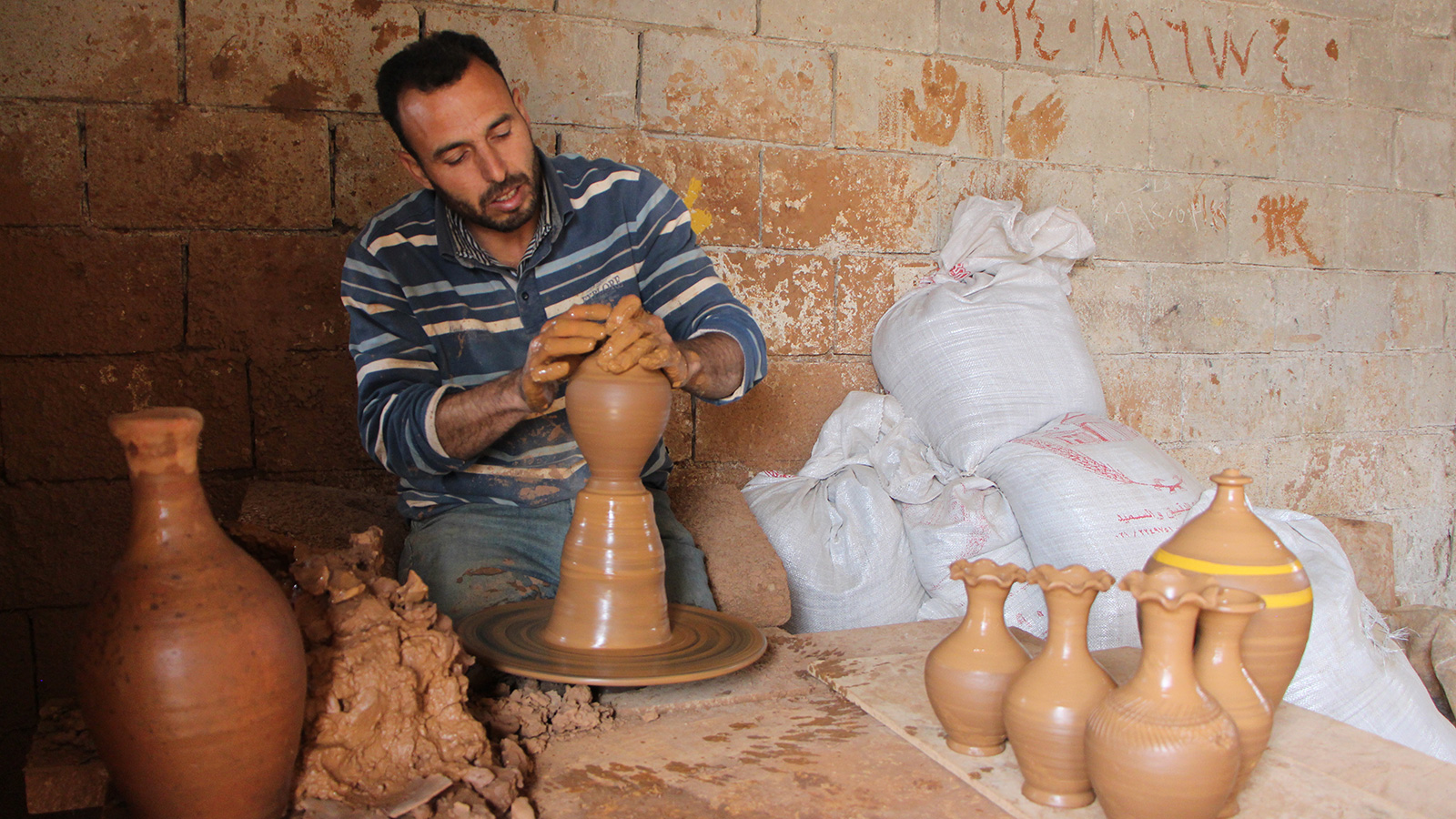‪أحد العاملين في مصنع الفخار بمدينة أرمناز شمال إدلب‬ (الجزيرة)