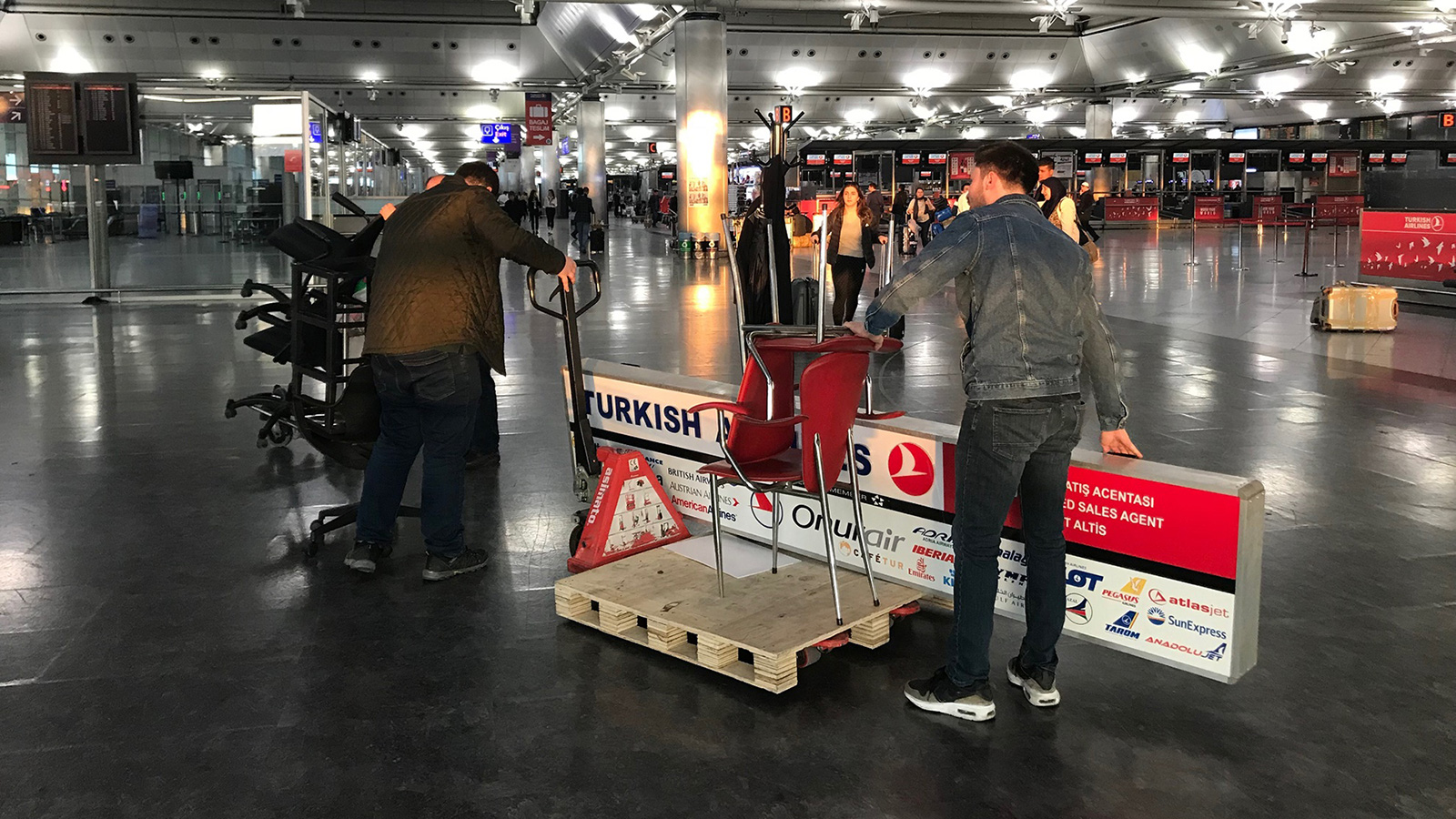 ‪أنور أوزونجو يتعاون مع زملائه لنقل مقتنيات مكتب الخطوط التركية في مطار أتاتورك قبيل إغلاقه‬ (الجزيرة)