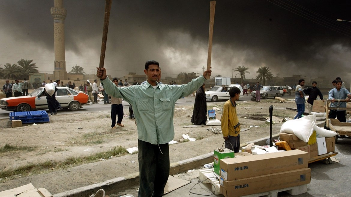An Iraqi man holds up wood in the midst of goods looted from a govermentbuilding in Baghdad April 9, 2003. Iraqis joyously welcomed U.S. Marinesdriving through eastern Baghdad on Wednesday and looters moved in as theremnants of Saddam Hussein's rule collapsed. Hundreds of jubilant Iraqischeered, danced, waved and threw flowers as Marines advanced through easternBaghdad and into the centre of Saddam's seat of power.    PP03040026REUTERS/Goran Tomasevic  GOT/FMSIRAQ