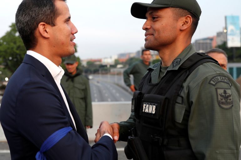 Venezuelan opposition leader Juan Guaido, who many nations have recognised as the country's rightful interim ruler, shakes hands with a military member near the Generalisimo Francisco de Miranda Airbase