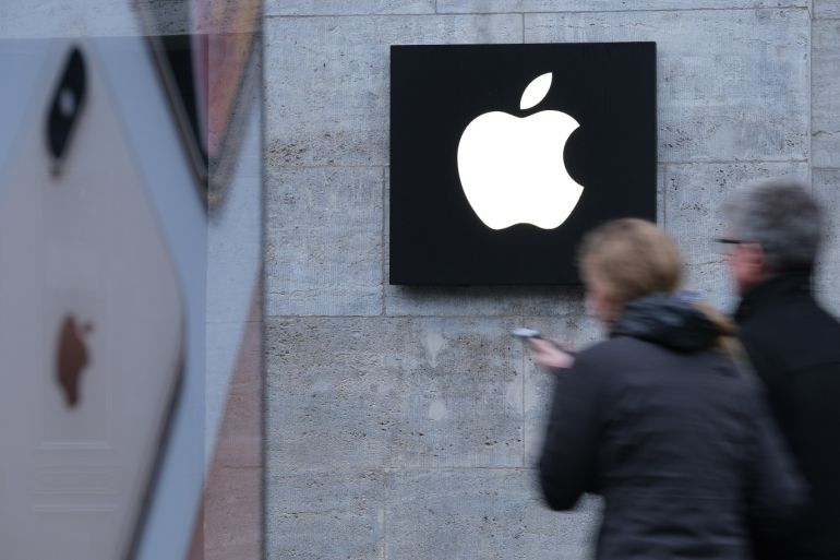 BERLIN, GERMANY - JANUARY 04: A woman holding a smartphone walks past the Apple Store on January 04, 2019 in Berlin, Germany. Apple has temporarily halted sales of its iPhone 7 and 8 models in Germany following a court case launched by Qualcomm over a possible patent infringement. (Photo by Sean Gallup/Getty Images)