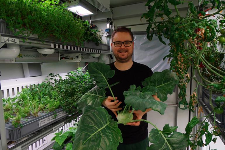 Said سعيد - فني في مشروع "إيدن آي إس إس" يحمل نباتا مزروعا بطريقة الزراعة الفضائية. موقع مشروع إيدن - البطاطس الفضائية..وإنتاج غذاء آمن في الفضاء