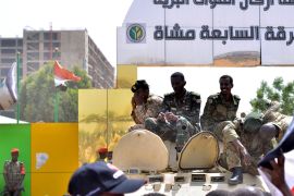 Sudanese military sit on their armoured personnel carrier (APC), after Sudan's Defense Minister Awad Mohamed Ahmed Ibn Auf said that President Omar al-Bashir had been detained
