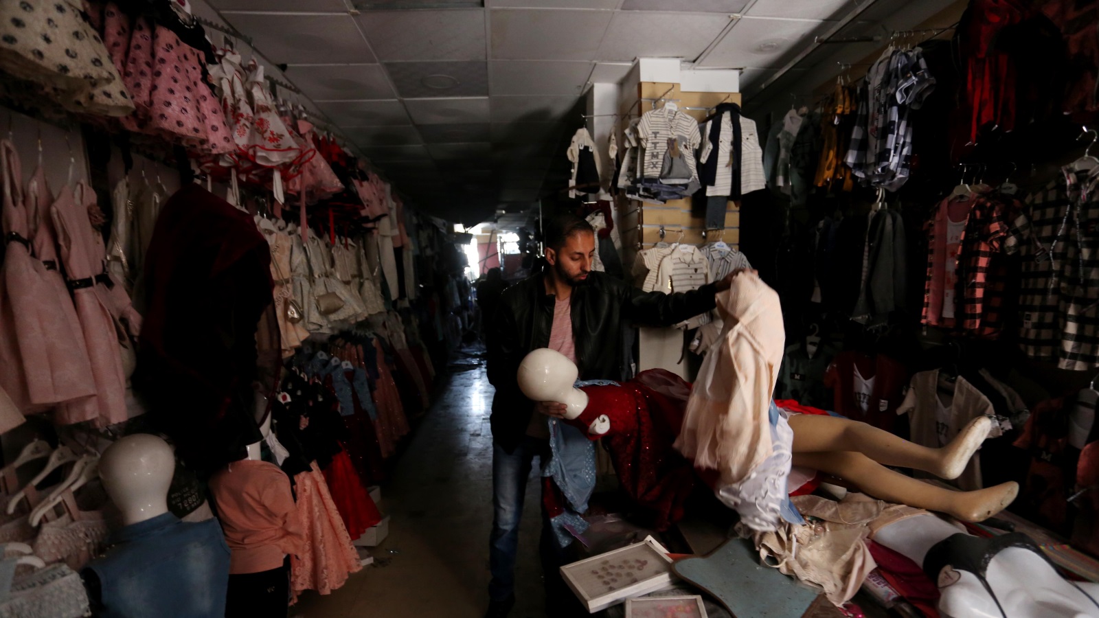 ‪فلسطيني يعاين محله عقب قصف الاحتلال للمبنى الذي يضم متجره بأحد أحياء غزة‬ (الأناضول)