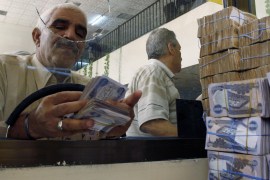 A client counts his money at Al-Rafidain bank in BaghdadJune 21, 2009. Total bank deposits in February -- the latest figures  available -- jumped by half to 36.6 trillion Iraqi dinars ($31 billion) from a year before, and loans surged 65 percent to 5.1 trillion dinars over the same period, central bank data show.  To match feature IRAQ/BANKS   REUTERS/Bassim Shati (IRAQ CONFLICT BUSINESS)