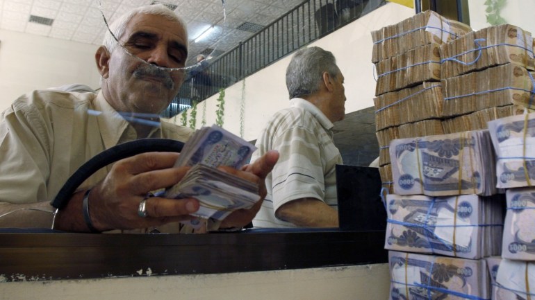 A client counts his money at Al-Rafidain bank in BaghdadJune 21, 2009. Total bank deposits in February -- the latest figures available -- jumped by half to 36.6 trillion Iraqi dinars ($31 billion) from a year before, and loans surged 65 percent to 5.1 trillion dinars over the same period, central bank data show. To match feature IRAQ/BANKS REUTERS/Bassim Shati (IRAQ CONFLICT BUSINESS)