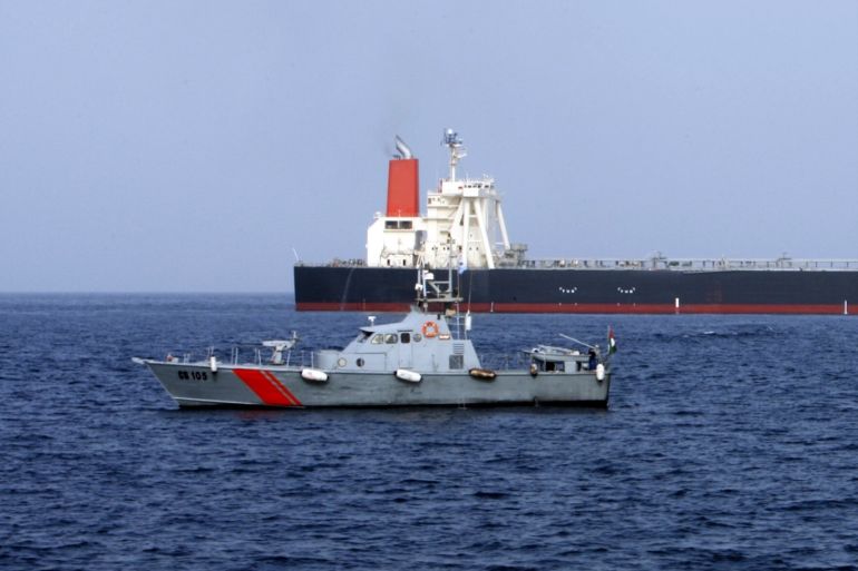 A UAE police boat sails past the M Star oil tanker at sea near Fujairah port in the United Arab Emirates July 29, 2010. A Japanese supertanker that reported suffering an