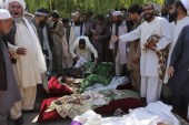 قرويون وأقارب يقفون بالقرب من جثث مدنيين قيل إنهم قتلوا خلال غارة جوية لحلف الناتو في مقاطعة هرات بأفغانستان في أغسطس/آب 2014 (رويترز)