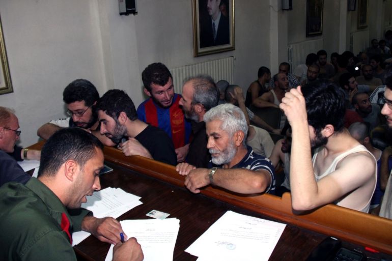 Syrian prisoners sign release papers at the Damascus Police Command headquarters in 2012.CreditBassem Tellawi/Associated Press