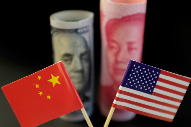 U.S. and Chinese flags are seen in front of a U.S. dollar banknote featuring American founding father Benjamin Franklin and a China's yuan banknote featuring late Chinese chairman Mao Zedong in this illustration picture taken May 20, 2019. Picture taken May 20, 2019. REUTERS/Jason Lee/Illustration