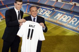 Gareth Bale (L) of Wales holds his new Real Madrid soccer club jersey with club president Florentino Perez at the Santiago Bernabeu stadium in Madrid September 2, 2013. The transfer window's longest-running saga finally ended on Sunday when Tottenham Hotspur forward Gareth Bale joined Real Madrid for a world transfer record fee of 100 million euros ($131.86 million). REUTERS/Paul Hanna (SPAIN - Tags: SPORT SOCCER)