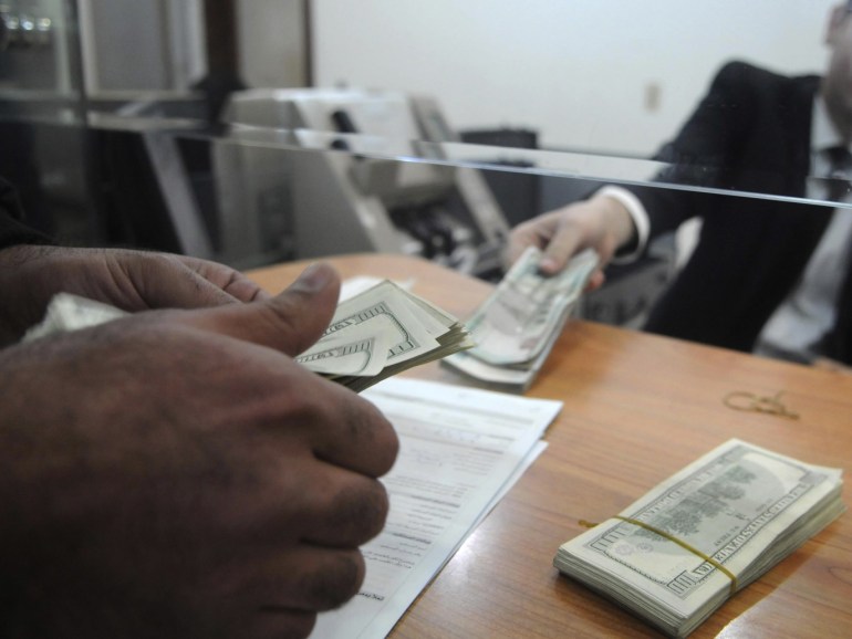 An employee of a money changer counts U.S. dollar notes for a customer at a bank in Cairo, December 31, 2013. Almost half of a sample of Middle East-based fund managers expect to raise equity allocations to Egypt in the next three months, according to the latest monthly Reuters survey of leading fund managers in the region. REUTERS/Stringer (EGYPT - Tags: BUSINESS)