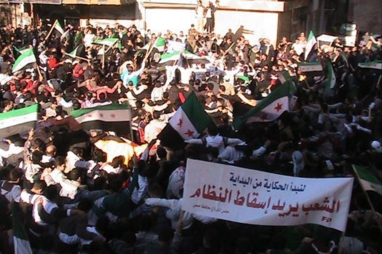 Demonstrators protesting against Syria's President Bashar al-Assad wave the old Syria flag as they march through the streets on the first day of the Muslim festival of Eid-al-Adha in Alsnmin near Daraa November 6, 2011. The banner reads,
