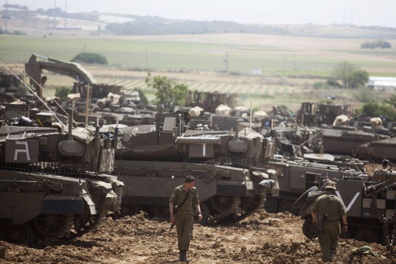 MAVKIM, ISRAEL - MAY 06: Israeli soldiers walks in front of a Merkava tanks, stationed near the border with the Gaza Strip on May 6, 2019 in Mavkim, Israel. Palestinian leaders in Gaza agreed a ceasefire with Israel on today to end a deadly two-day escalation in violence that threatened to widen into war. (Photo by Lior Mizrahi/Getty Images)