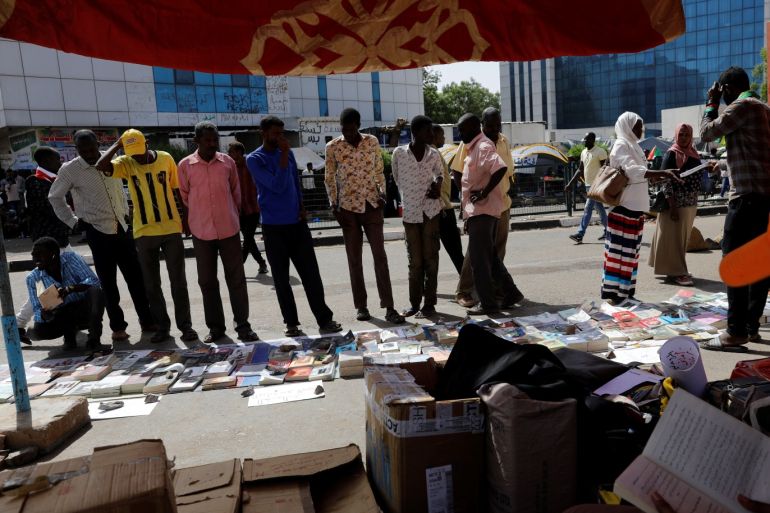 People look, choose and read free books in front of a tent in front of the defence ministry compound in Khartoum, Sudan, April 29, 2019. Picture taken April 29, 2019. REUTERS/Umit Bektas