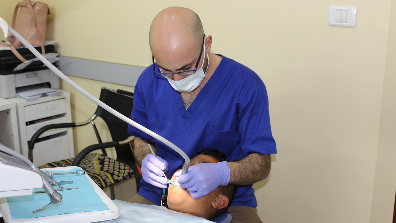 طبيب الأسنان المقدسي مجد يمارس مهنته في عيادته برأس العامود بالقدس (الجزيرة)