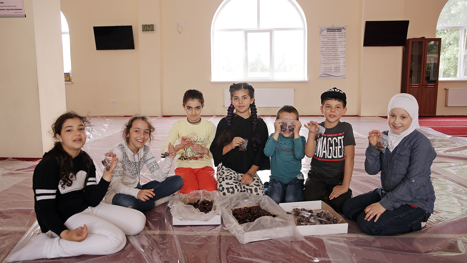 ‪أطفال كييف يشاركون في إعداد أكياس التمر لتوزيعها على الصائمين قبل الإفطار‬ (الجزيرة)