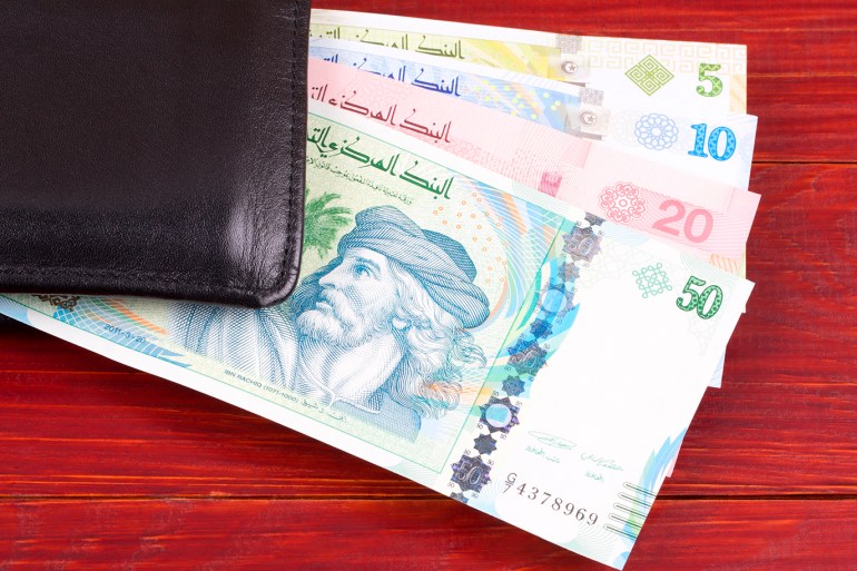 Tunisian money in the black wallet on a wooden background