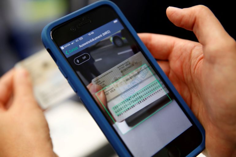 A German police officer scans an ID card with a phone using newly developed smartphone app 'mobi.kom', during a presentation in Dortmund, Germany, June 7, 2019. REUTERS/Wolfgang Rattay/Illustration
