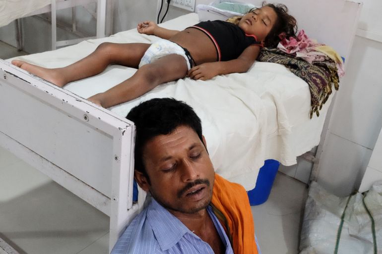 A man sleeps next to his daughter who is suffering from acute encephalitis syndrome at a hospital in Muzaffarpur, in the eastern state of Bihar, India, June 20, 2019. Picture taken on June 20, 2019. REUTERS/Alasdair Pal