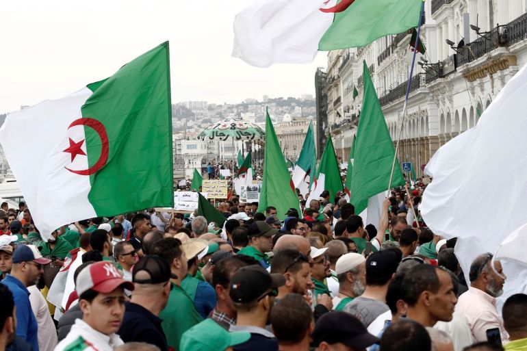 Demonstrators carry national flags during a protest to demand the postponement of a presidential election and the removal of the ruling elite in Algiers, Algeria May 24, 2019. REUTERS/Ramzi Boudina