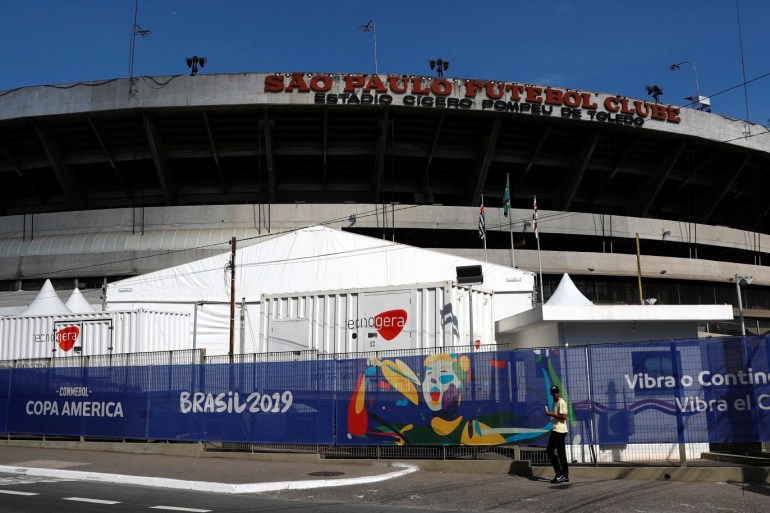 A man walks past banners near the entrance at the Morumbi Stadium, Sao Paulo, Brazil June 12, 2019. REUTERS/Henry Romero