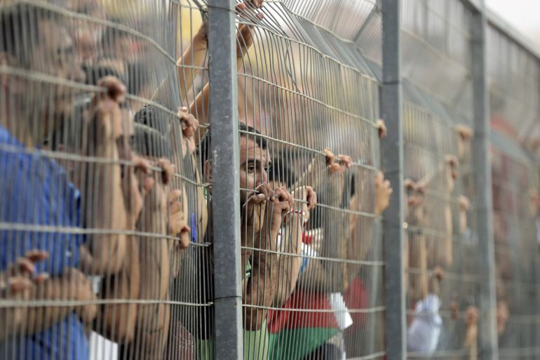Fans look through a fence as they watch the 2018 World Cup qualifying soccer match between Palestine and the United Arab Emirates, at Faisal al-Husseini Stadium, in the occupied West Bank town of Al-Ram near Jerusalem September 8, 2015. REUTERS/Ammar Awad